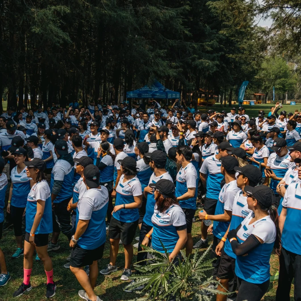 Gran grupo de participantes en un evento de integración al aire libre en un parque.