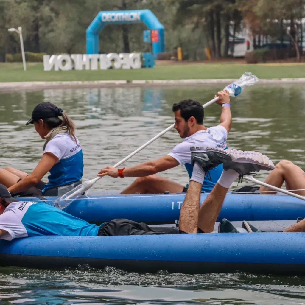 Participantes realizando actividades de remo en un lago como parte de un evento de integración.