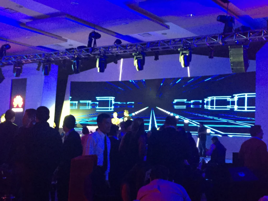 Escenario iluminado con luces dinámicas en un evento empresarial.