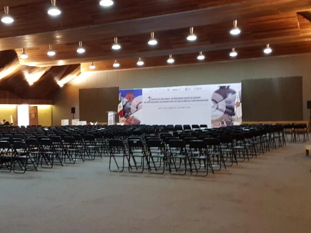 Salón con sillas alineadas y una pantalla lista para iniciar una conferencia empresarial.