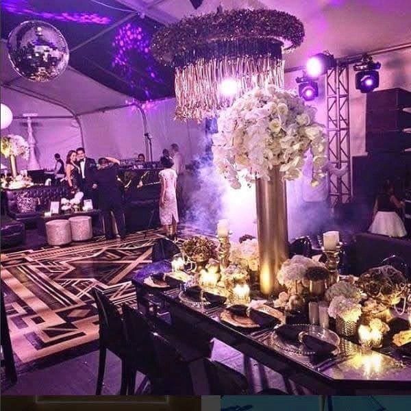 Mesa de gala decorada con arreglos florales altos y luces cálidas en un evento empresarial