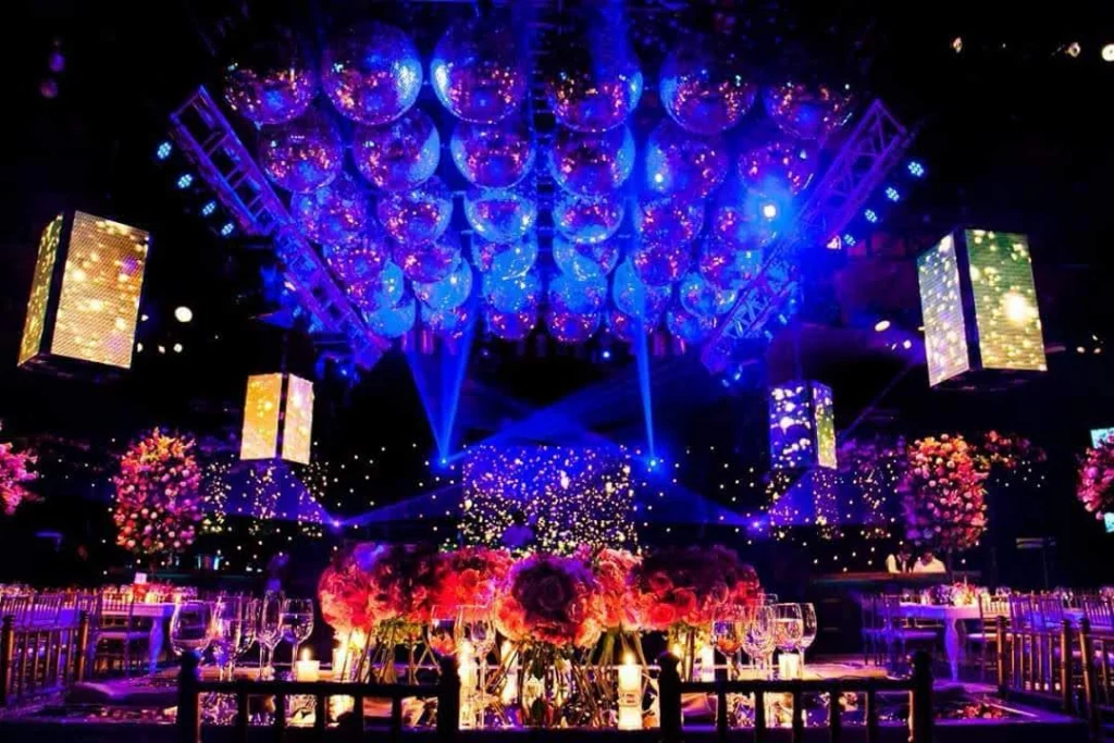 Salón decorado con esferas colgantes e iluminación azul para un evento corporativo.